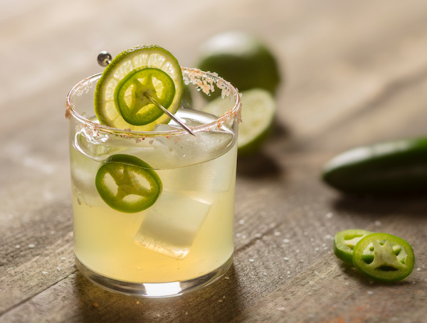 Spicy Margarita with fresh jalapeno and lime on wood background